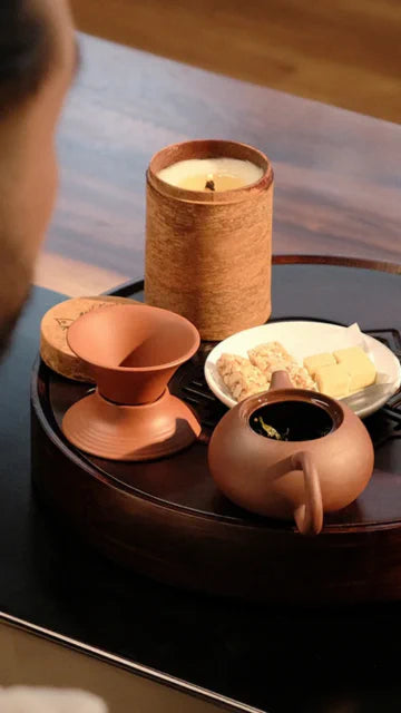 Le Rustique candle with Tea set on a wooden surface for aromatherapy